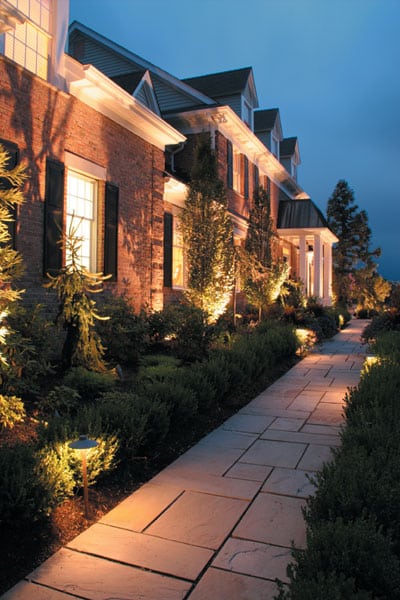 Large, redbrick home with a well lit exterior.