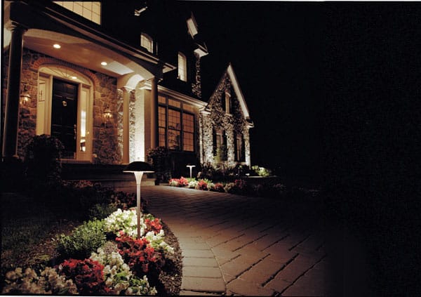 Large house with a well lit exterior and garden.