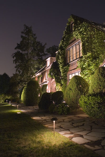 Large, redbrick home with a well lit exterior.