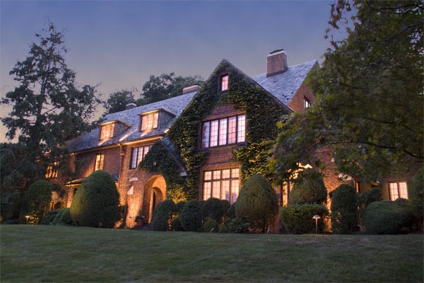 Large, redbrick home with a well lit exterior.